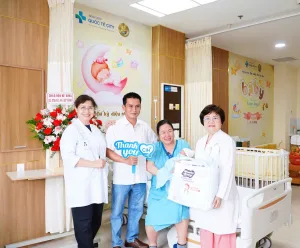 Hình ảnh bác sĩ Bệnh viện Quốc tế City trao quà chúc mừng gia đình chị Đ.T.H.N sau hành trình IVF thành công sau 10 năm hiếm muộn