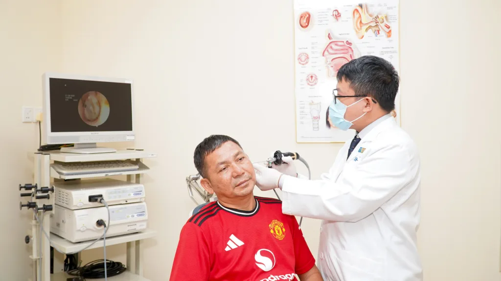 ThS.BS. Nguyễn Lê Nhân Văn, bác sĩ Trung tâm Tai Mũi Họng Chuyên sâu và Phẫu thuật Đầu Cổ, nội soi tai cho người bệnh trong lần tái khám.